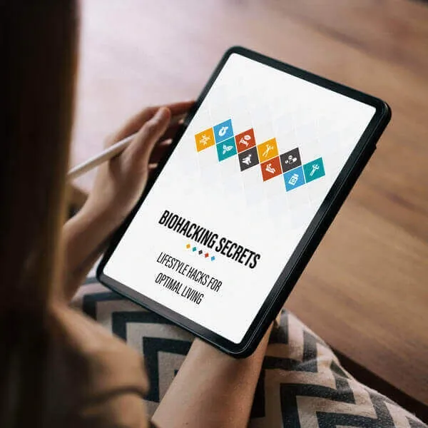A person holding a tablet that shows the e-book cover Biohacking Secrets